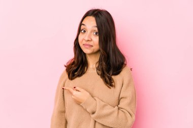 Genç, melez İspanyol bir kadın izole edilmiş, gülümseyen ve işaret eden boş alanda bir şey gösteriyor..