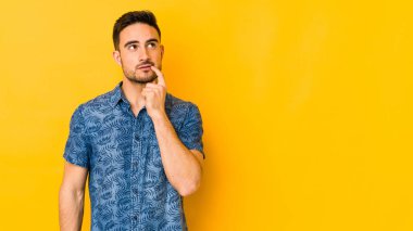 Kafkasyalı genç adam sarı fırında izole edilmiş şüpheli ve şüpheci bir ifadeyle yana bakıyor..