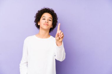 Afrika kökenli Amerikalı küçük çocuk bir numarayı parmaklarıyla gösterdi..