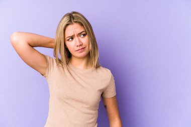 Sarışın, beyaz bir kadın. Kafasının arkasına dokunuyor, düşünüyor ve bir seçim yapıyor..