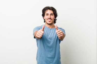 Beyaz bir geçmişi olan genç ve yakışıklı bir adam. Başparmakları havada, bir konuda tezahürat yapıyor, destek oluyor ve saygı duyuyor..