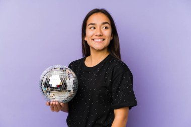 Bir balo düzenleyen Asyalı genç bir kadın yalnız. Gülümsüyor, neşeli ve keyifli görünüyor..