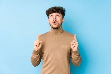 Genç Arap adam, ağzı açık, üst tarafı işaret ederek izole edilmiş..