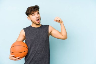 Basketbol oynayan genç bir Arap, galibiyet konseptinden sonra yumruğunu kaldırıyor..