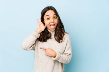 Genç, Latin kökenli bir kadın bir dedikoduyu dinlemeye çalışıyor..