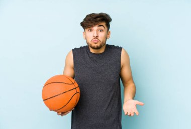 Sepet oynayan genç bir Arap omuz silkiyor ve gözleri açık..