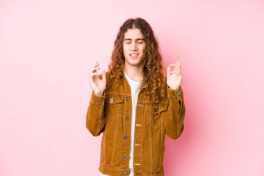 Uzun saçlı genç adam neşeli bir şekilde gülüyor. Mutluluk kavramı.