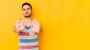Sarı fırında izole edilmiş genç beyaz bir adam elini uzatmış, dur işareti göstererek seni engelliyor..