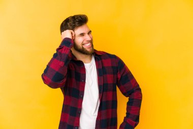 Sarı arka planda izole edilmiş genç beyaz adam zaferi, tutkuyu ve coşkuyu kutluyor, mutlu bir ifade..