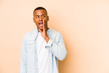 Bej arka planda izole edilmiş genç latin adam gizli bir sıcak fren haberinin olduğunu söylüyor.