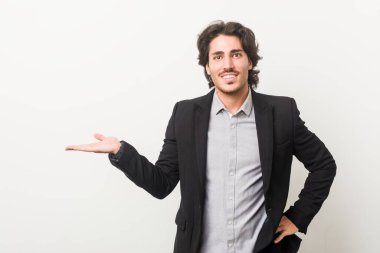 Beyaz arka planda çalışan genç bir iş adamı bir avuç içinin fotokopi çektiğini ve belinde bir el daha tuttuğunu gösteriyor..