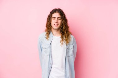 Uzun saçlı adam yalnız gülüyor ve gözlerini kapatıyor, rahatlamış ve mutlu hissediyor..