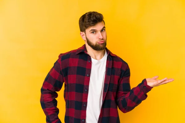 Joven Hombre Caucásico Aislado Sobre Fondo Amarillo Mostrando Espacio Copia —  Fotos de Stock