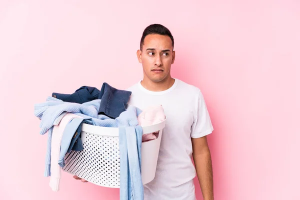 Ung Latin Man Plocka Upp Smutsiga Kläder Isolerad Förvirrad Känns — Stockfoto