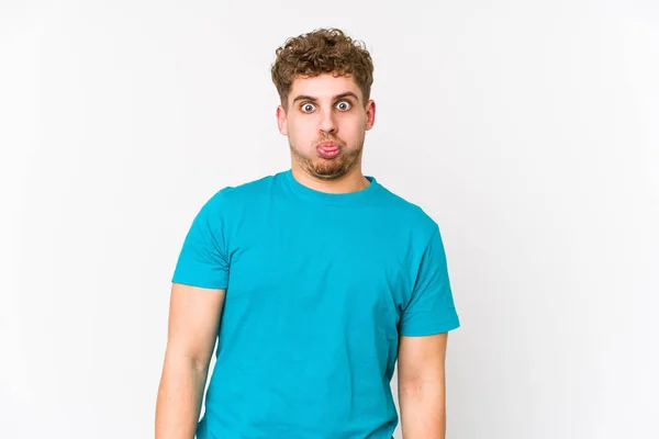 Young Blond Curly Hair Caucasian Man Isolated Blows Cheeks Has — Stock Photo, Image