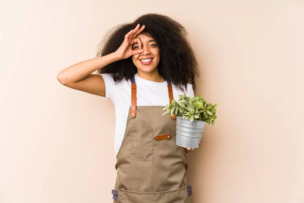 Jovem Afro Jardineiro Mulher Segurando Uma Planta Isoladodexcited Mantendo Gesto — Fotografia de Stock