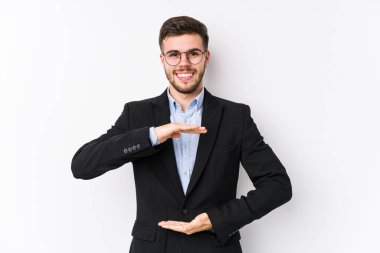 Beyaz arka planda poz veren Kafkasyalı genç bir iş adamı iki eliyle bir şey tutan Kafkasyalı genç bir iş adamını izole etti..
