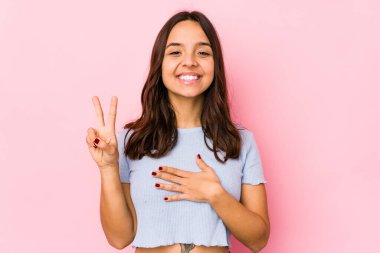 Genç, melez, Latin bir kadın tek başına yemin ediyor, elini göğsüne koyuyor..