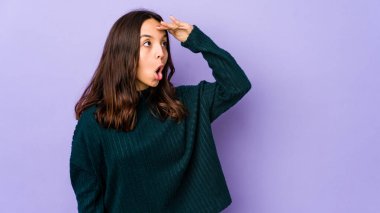 Genç, Latin kökenli bir kadın. Uzaklara bakıyor. Alnına el koyuyor..