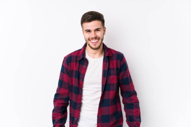 Beyaz arka planda poz veren beyaz bir genç adam neşeli bir şekilde gülüyor. Mutluluk kavramı.