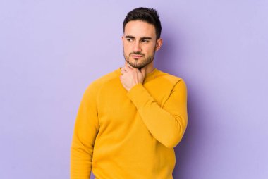 Mor arka planda izole edilmiş genç beyaz bir adam virüs veya enfeksiyon yüzünden boğazında ağrı hissediyor..