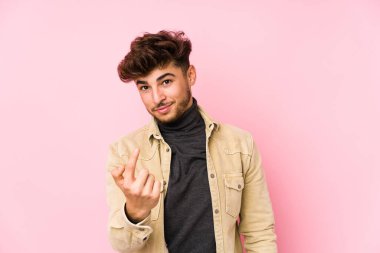 Arka planda yalnız poz veren genç bir Arap sizi parmağıyla işaret ederek sanki sizi davet ediyormuş gibi..