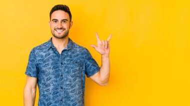 Sarı fırında izole edilmiş genç beyaz adam boynuzlarını devrim konsepti olarak gösteriyor..