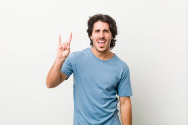 Beyaz arka planda genç yakışıklı bir adam boynuzlarını devrim konsepti olarak gösteriyor..