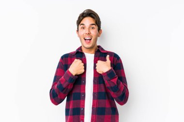 Pembe arka planda poz veren genç beyaz bir adam..