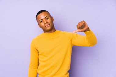 Mor arka planda izole edilmiş genç bir latin jestten hoşlanmadığını gösteriyor. Anlaşmazlık konsepti.