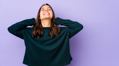 Genç, melez İspanyol kadın kendini soyutlamış, kendinden emin, elleri başının arkasında..