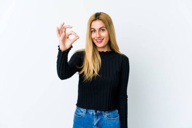 Genç sarışın kadın, beyaz arka planda izole edilmiş neşeli ve kendinden emin, iyi bir hareket gösteriyor..