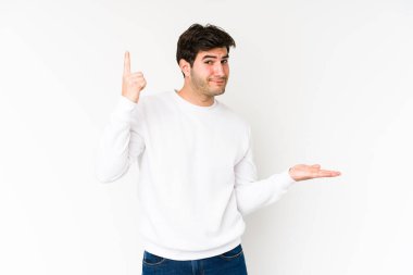 Beyaz arka planda izole edilmiş genç bir adam elinde bir ürün tutuyor..