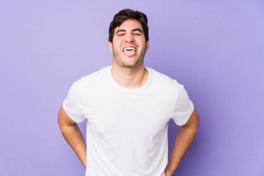 Mor arka planda izole edilmiş genç bir adam komik ve dost canlısı bir dil uzatıyor..