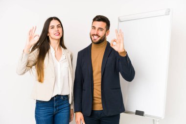 Genç beyaz iş çifti neşeli ve kendinden emin bir şekilde iyi niyet gösteriyorlar..