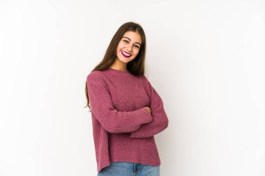 Beyaz arka planda kendini güvende hisseden, kararlılıkla kollarını kavuşturan beyaz tenli genç bir kadın..