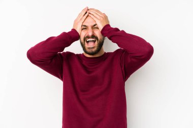 Beyaz bir arka planda izole edilmiş genç, uzun saçlı adam ellerini başının üstünde tutarak neşe içinde gülüyor. Mutluluk kavramı.