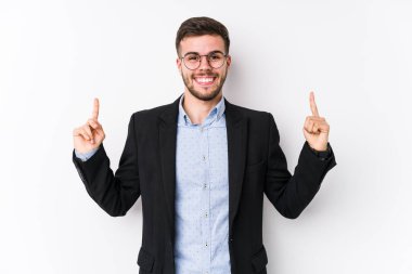 Beyaz arka planda poz veren beyaz tenli genç beyaz iş adamı genç Kafkasyalı iş adamının işaret ettiği gibi iki eli de boş bir boşluk gösteriyor..