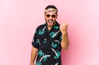 Genç hippi izole edilmiş, kameraya yumruk sallıyor, agresif yüz ifadesi var..