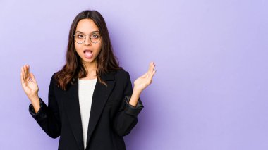 Genç, Latin kökenli bir kadın, kendini izole etmiş, parmaklarıyla küçük bir şey tutuyor, gülümsüyor ve kendinden emin..