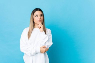 Kafkasyalı genç bir kadın şüpheli ve şüpheci bir ifadeyle yanlamasına bakıyor..