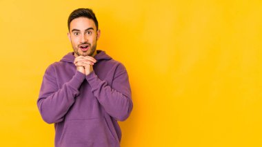 Kafkasyalı genç adam sarı fırında izole edilmiş şans için dua ediyor, şaşırmış ve ağzını açıp önüne bakıyor..