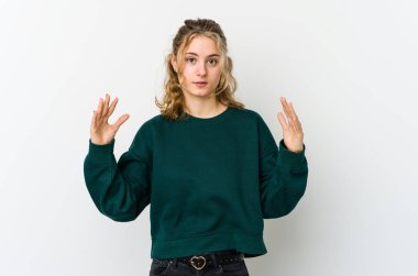 Beyaz sırtında beyaz bir kadın, parmaklarıyla küçük bir şey tutuyor, gülümsüyor ve kendinden emin..