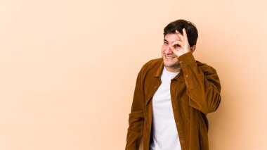 Bej arka planda izole edilmiş genç bir adam heyecanlı..