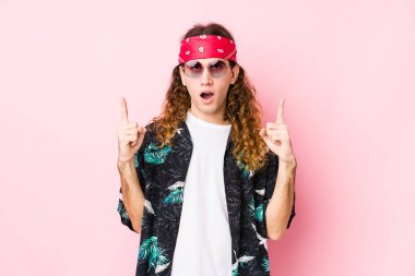 Kafkasyalı genç hippi, ağzı açık, üst tarafı işaret ediyor..