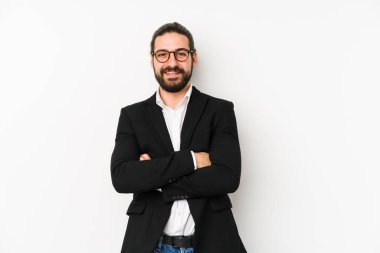 Kafkasyalı genç iş adamı beyaz bir arka planda izole edilmiş, kendinden emin, kararlılıkla kollarını kavuşturuyor..