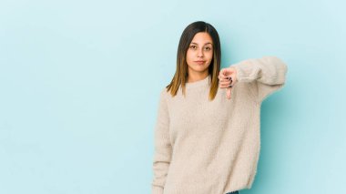 Mavi arka planda izole edilmiş genç bir kadın hoşlanmadığı bir hareket gösteriyor. Anlaşmazlık konsepti.