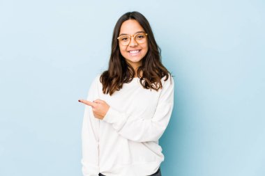 Genç, melez İspanyol bir kadın izole edilmiş, gülümseyen ve işaret eden boş alanda bir şey gösteriyor..