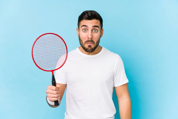 Jovem Bonito Homem Jogando Badminton Isolado Encolhe Ombros Olhos Abertos — Fotografia de Stock