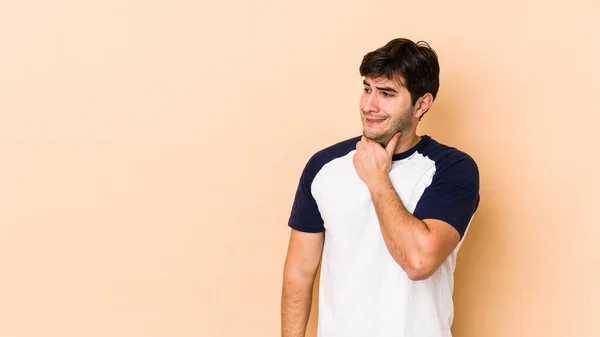 Jovem Isolado Fundo Bege Tocando Parte Trás Cabeça Pensando Fazendo — Fotografia de Stock